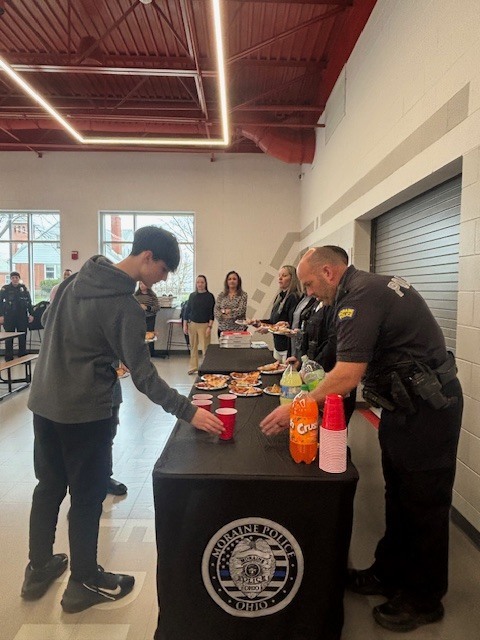 Police officer handing a cup to a child