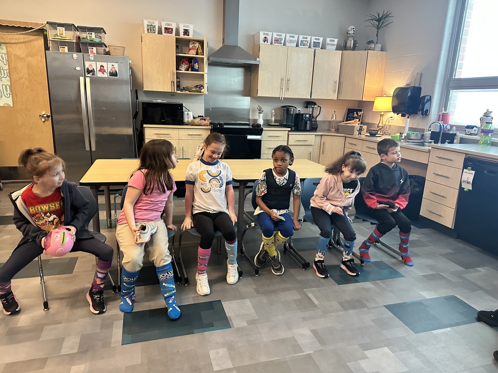 six students wearing crazy or mismatched socks