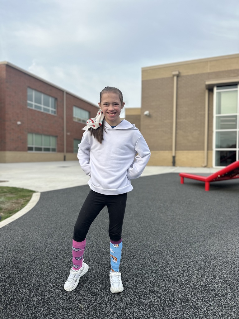 student showing off her mismatched socks while standing on the playground