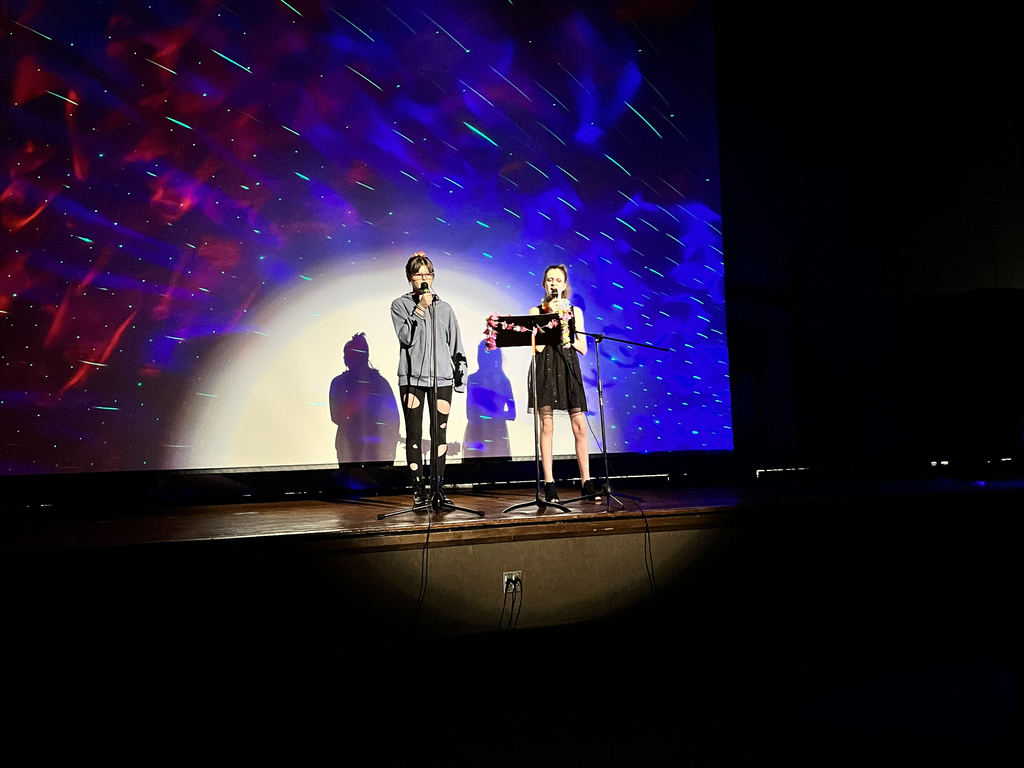 two girls on stage singing