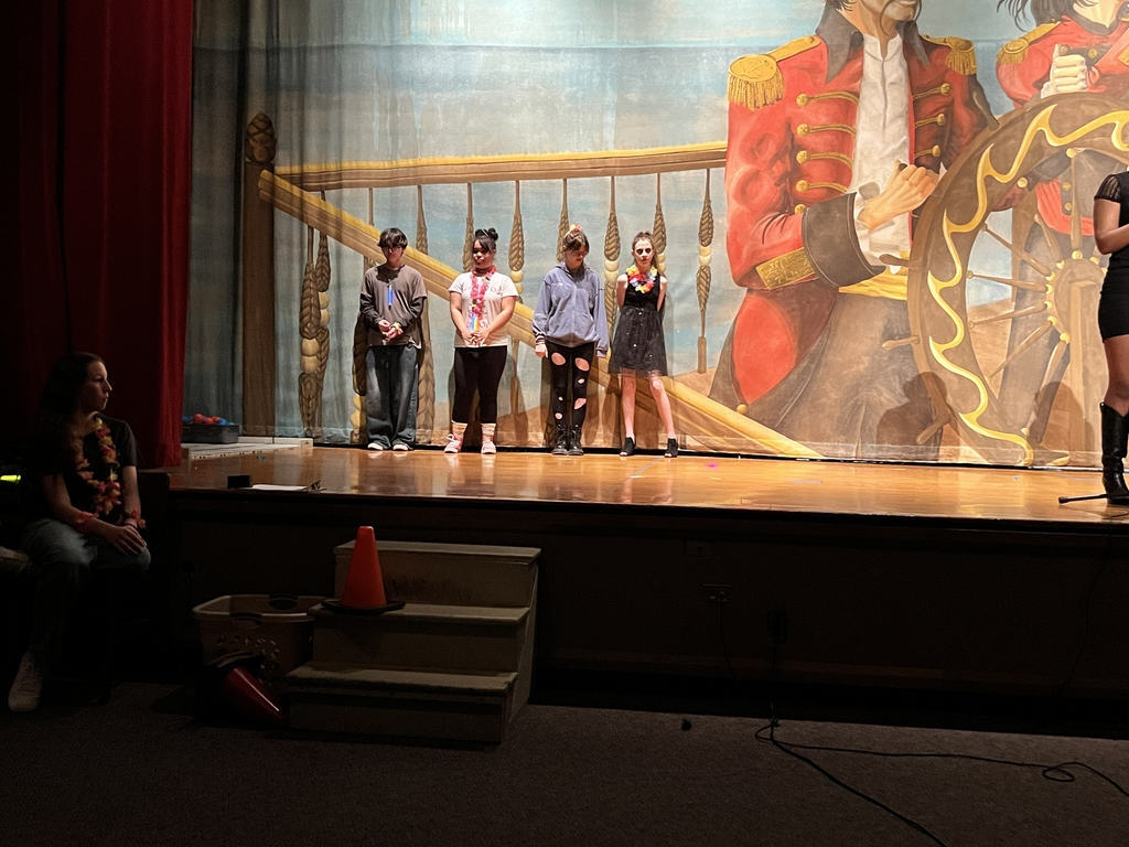 four students standing on stage