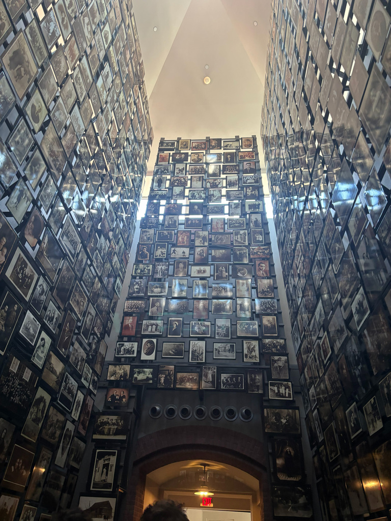 A vertical view of a room with walls covered in many framed photographs, creating an extensive gallery.