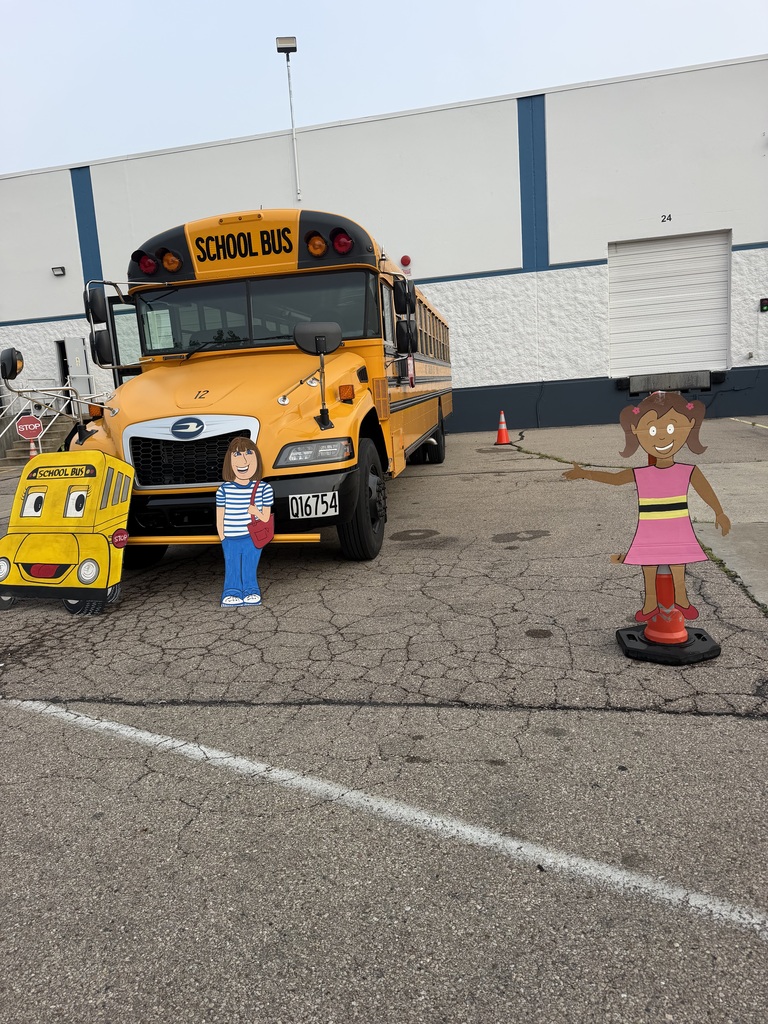 A yellow school bus with "SCHOOL BUS" on the side, parked in a parking lot with two small figures.