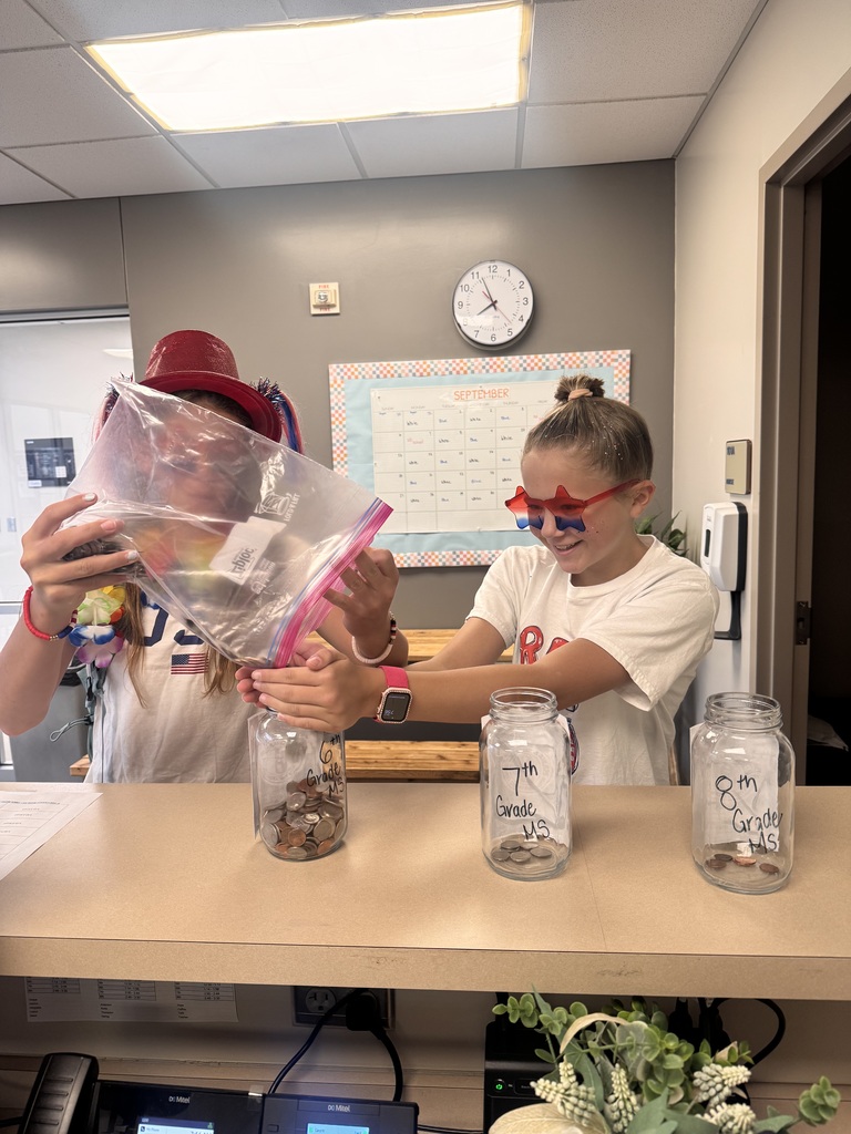 6th Graders, Brooke B and Kenzi M, filling up the 6th Grade coin jar.