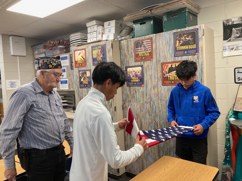 Students folding a flag.