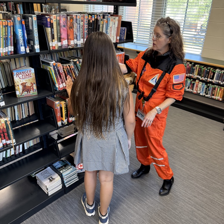 Ms. Lathrop helps a student find a book