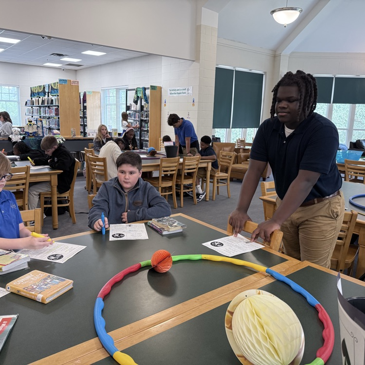 Student workers play a game with sixth graders