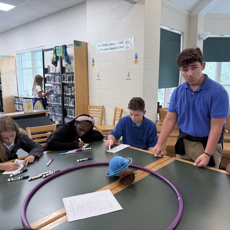 A library leader plays a game with sixth graders