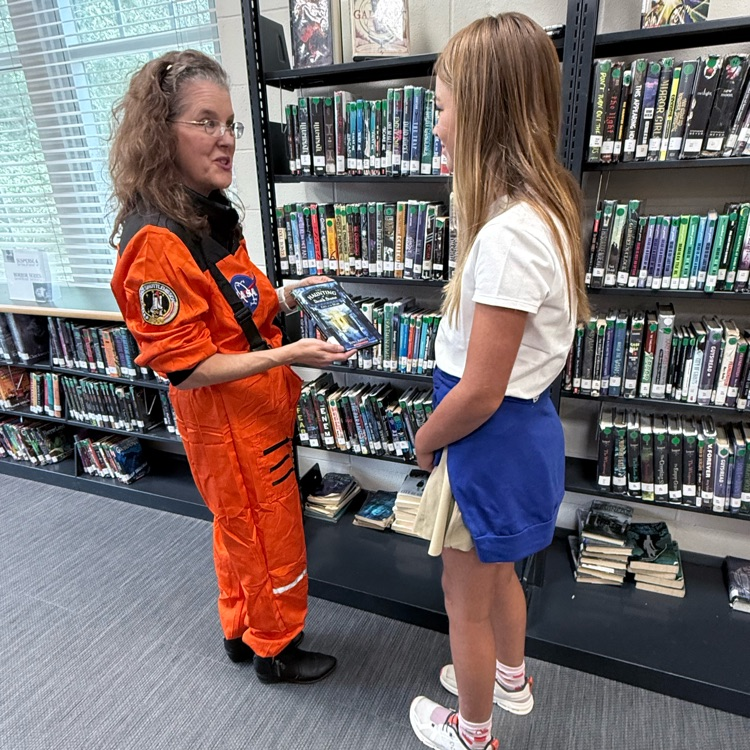 Ms. Lathrop helps a student find a book
