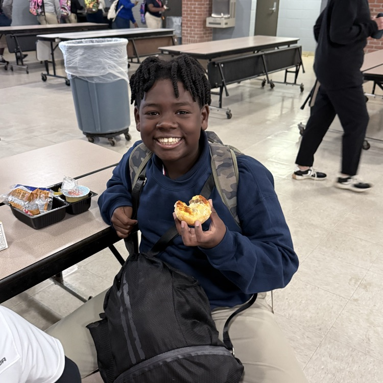 Student smiling with bagel