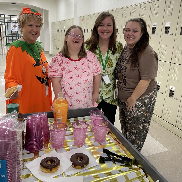 Staff members enjoy a doughnut and coffee