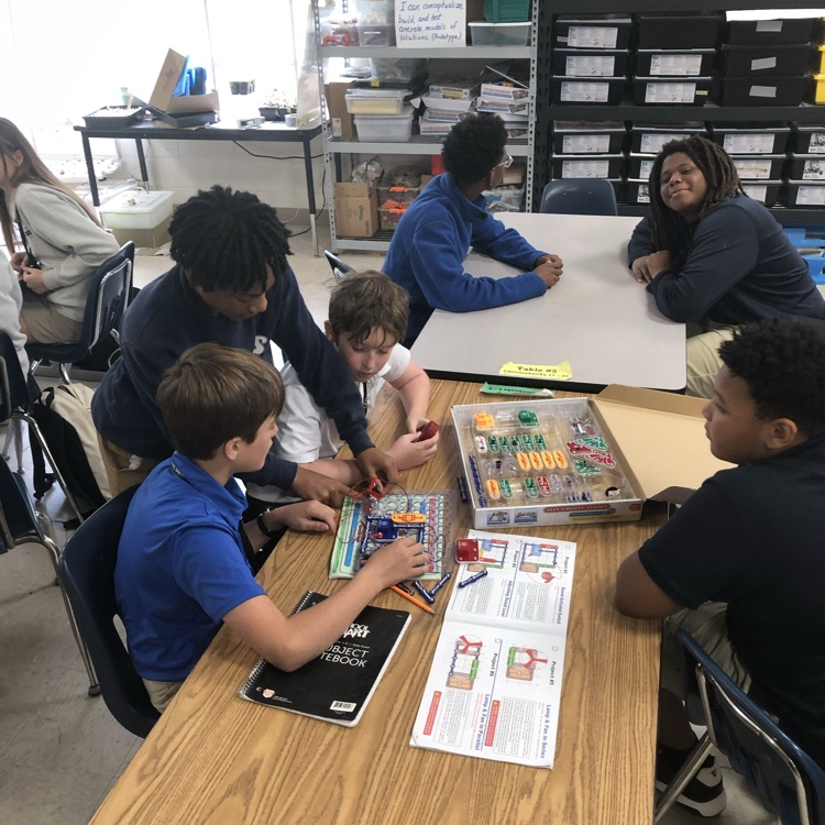 Volunteers from Entergy work with students