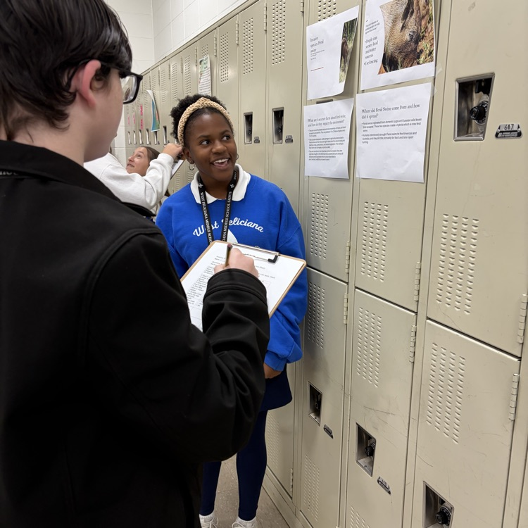 students collaborating on a project in the hallway