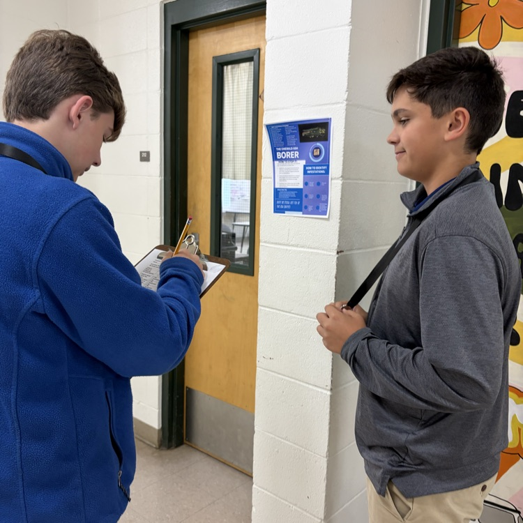students collaborating on a project in the hallway