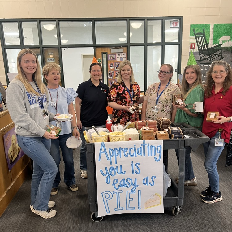 Teachers pose by the pie cart 