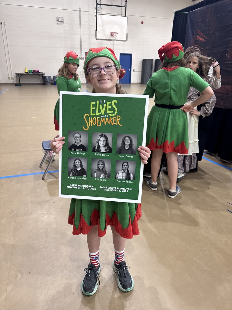 Student stands with play poster.