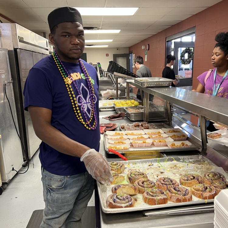 cafeteria staff member hands out king cakes