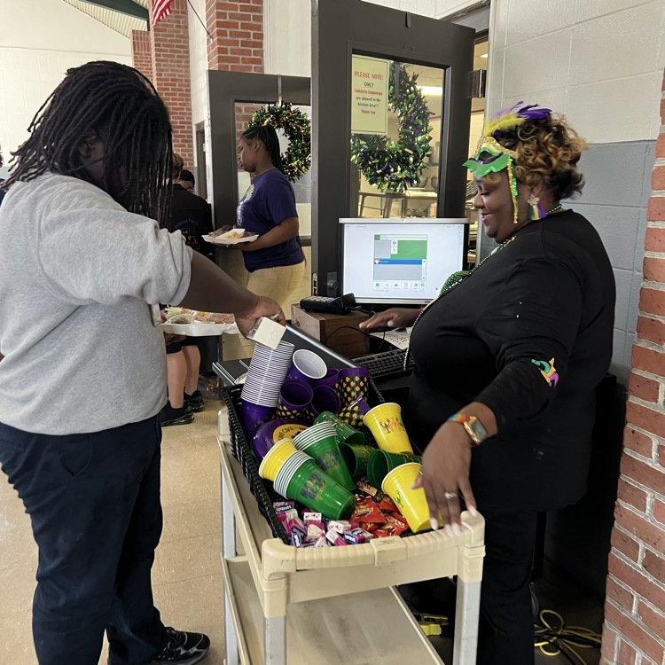 cafeteria Manager, Ms. Liza Haile, hands out Mardi Gras treats