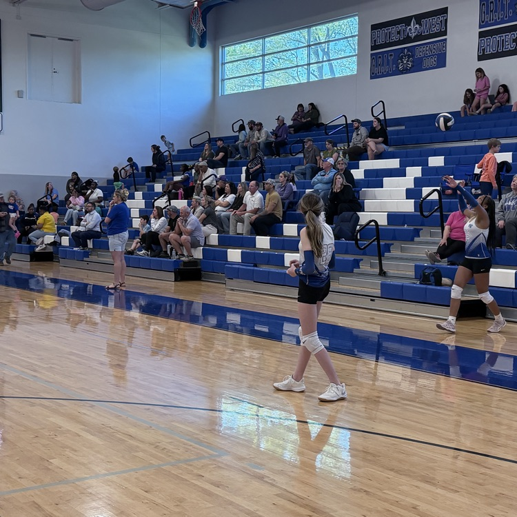 Student serves the volleyball . 