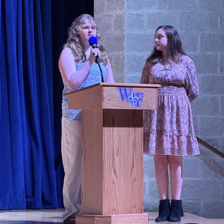 students speak at podium 
