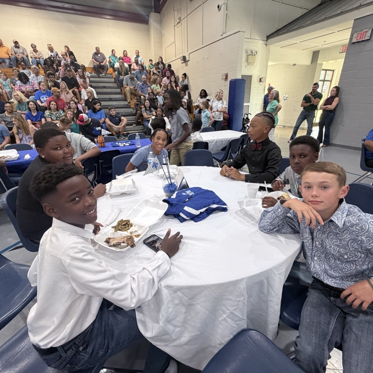 Students sit with teammates. 