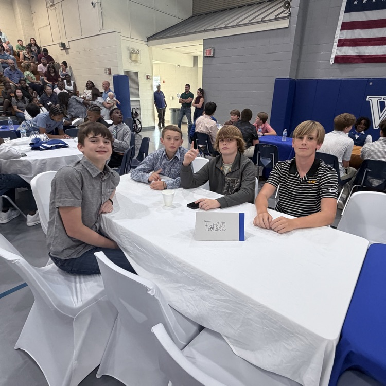 Students sit with teammates. 