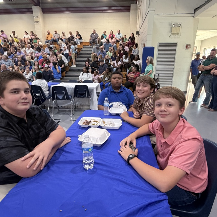 Students sit with teammates. 