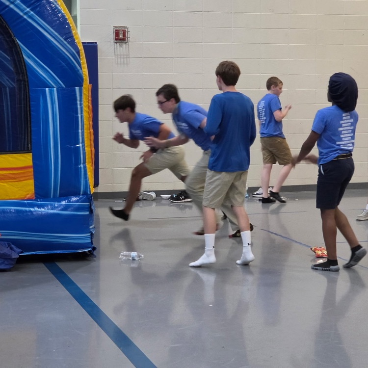 students running toward an inflatable slide