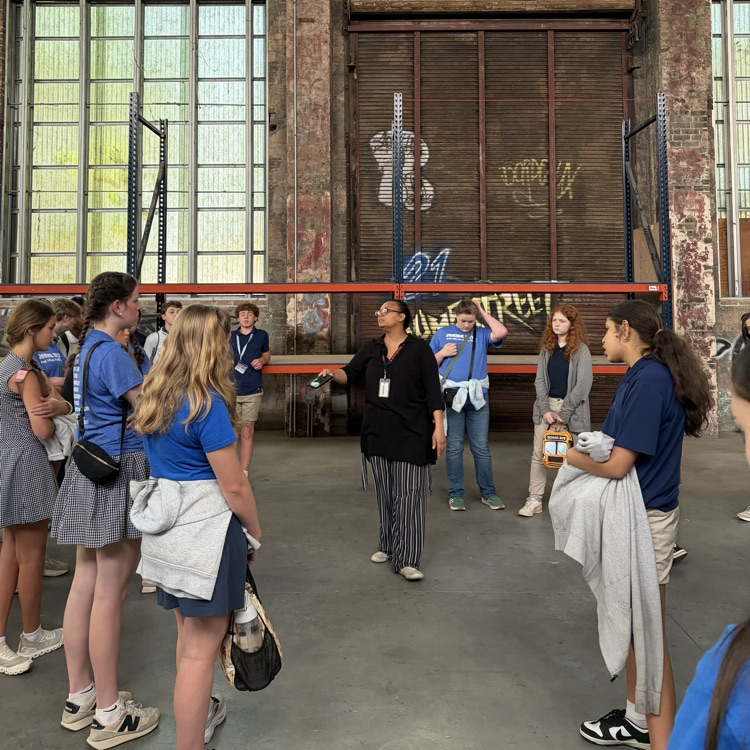 students listen to a speaker in a large movie studio