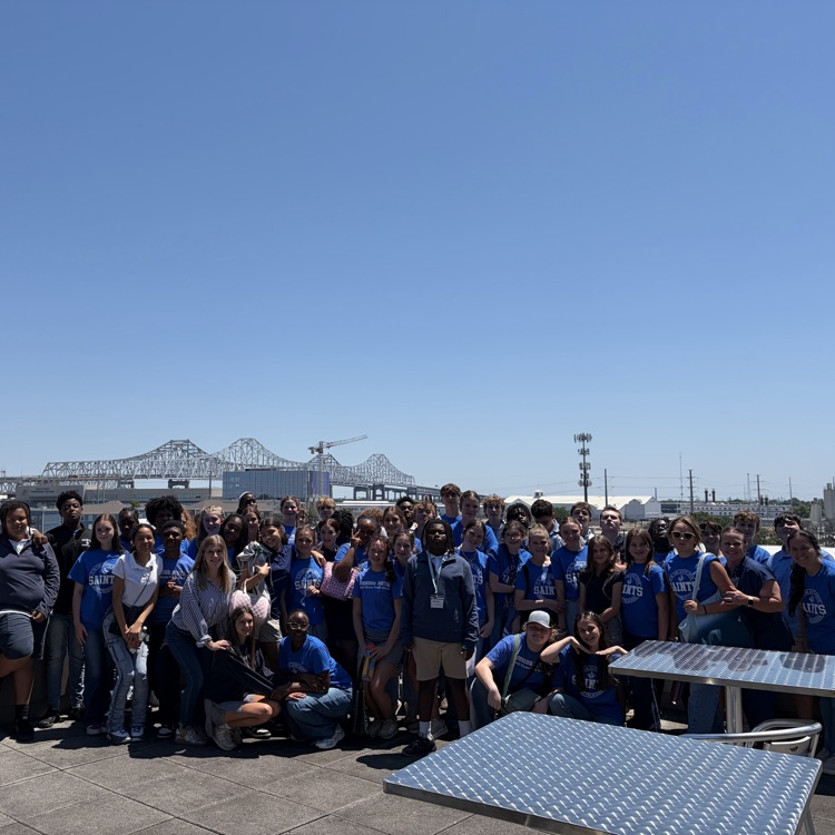large group of students picked in front of bridge