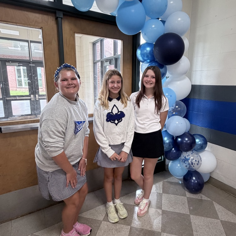 students pose in front of a balloon