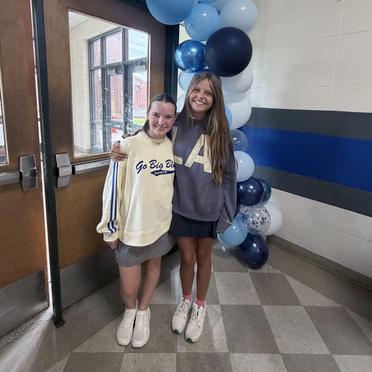 Students pose in front of a balloon arch