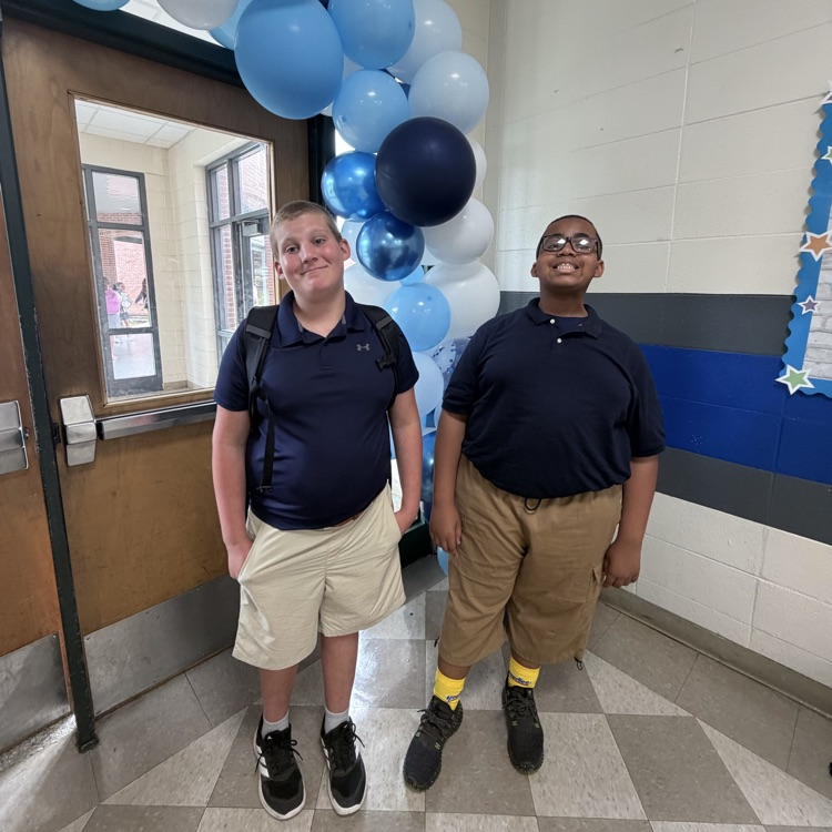 students pose in front of a balloon arch