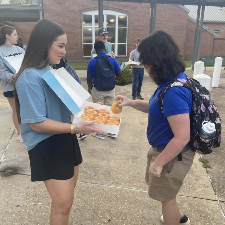 WyldLife leaders pass out donuts to students