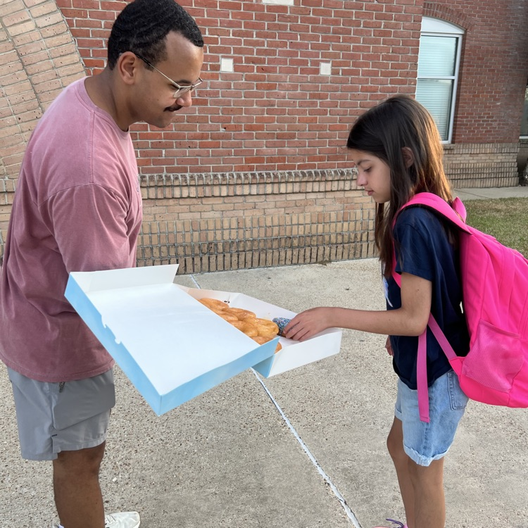WyldLife leaders pass out donuts to students