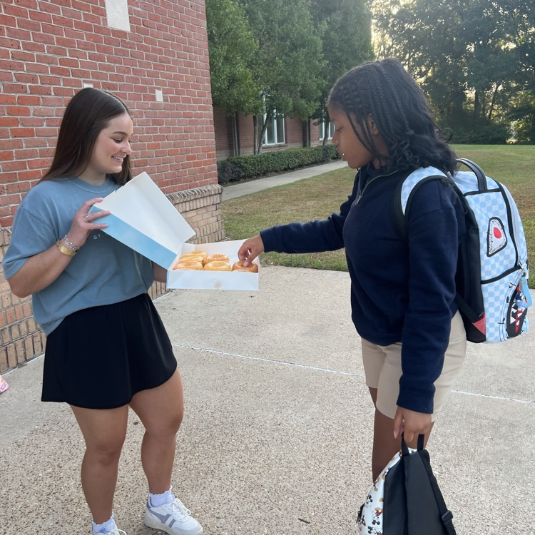 WyldLife leaders pass out donuts to students