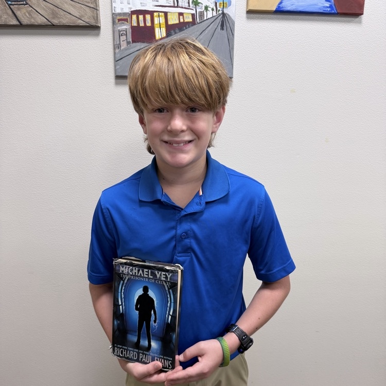 Wyatt Stogner poses with library book  