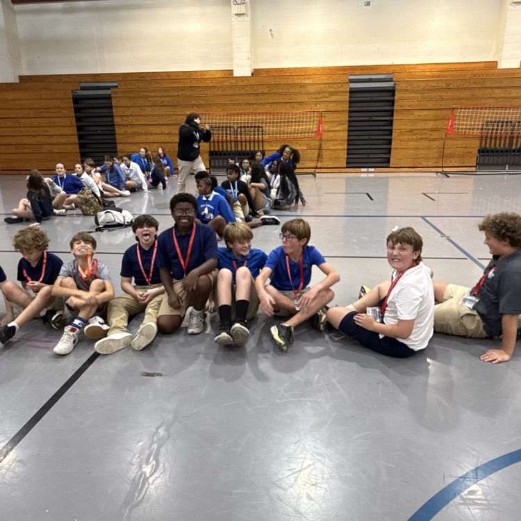 smiling students seated in the gym