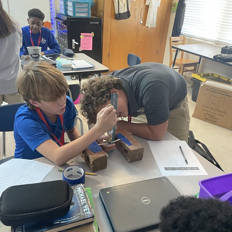 two students conduct an experiment