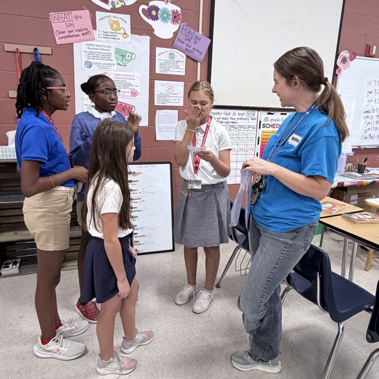 smiling students gathered around a teacher