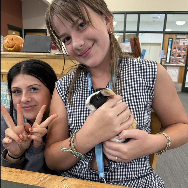 students hold a guinea pig