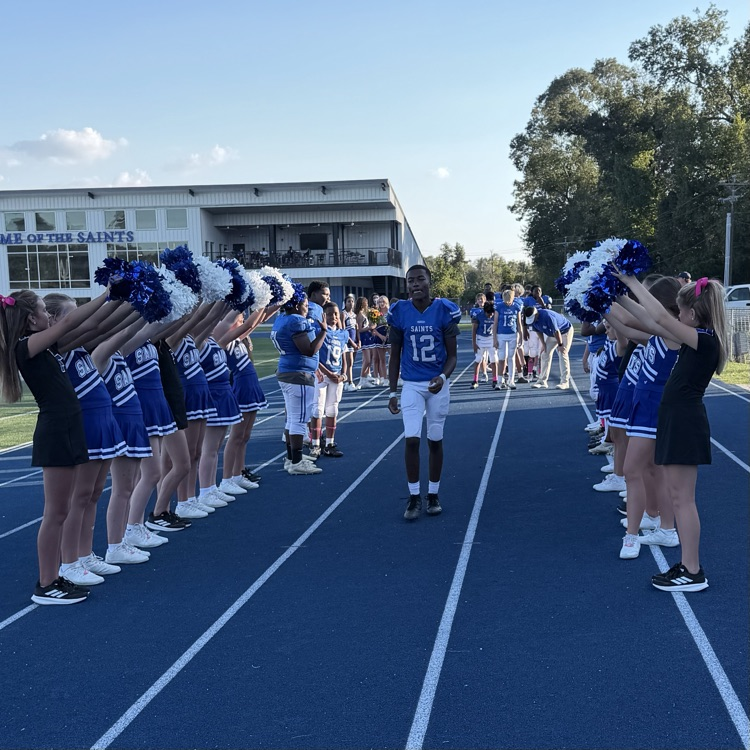 8th grade student athlete walks through cheer tunnel