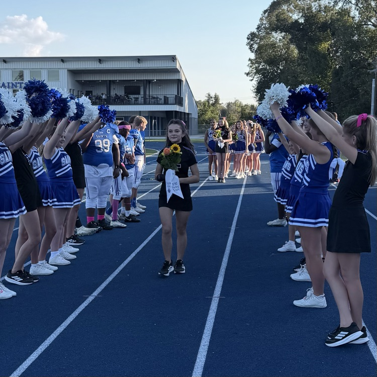 8th grade student athlete walks through cheer tunnel
