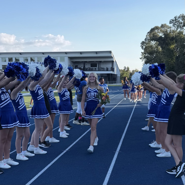 8th grade student athlete walks through cheer tunnel