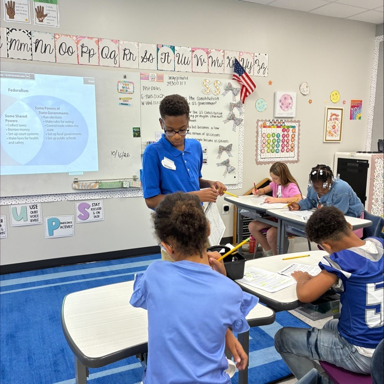 middle school student works with elementary students