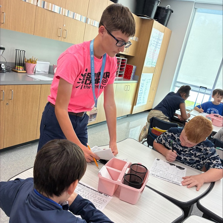 middle school student works with elementary student