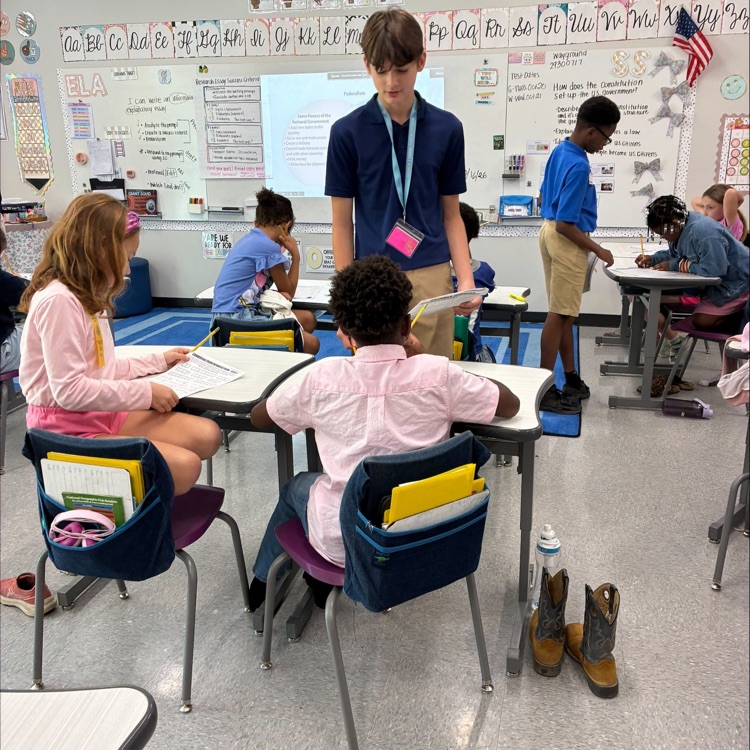 middle school student works with elementary students