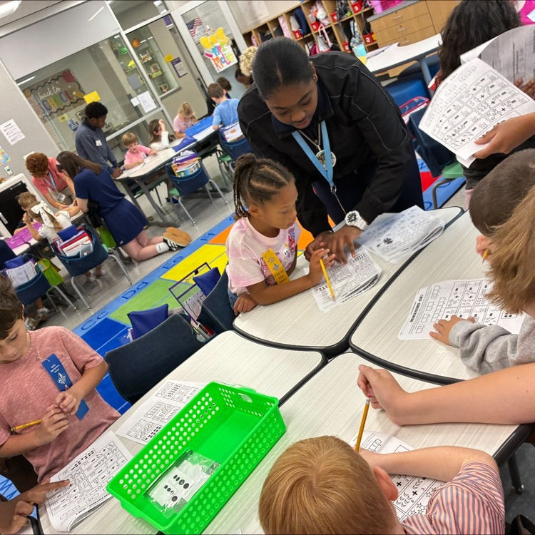 middle school student works with elementary students