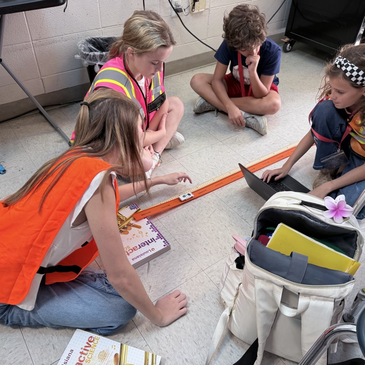 students conduct an experiment with matchbox cars