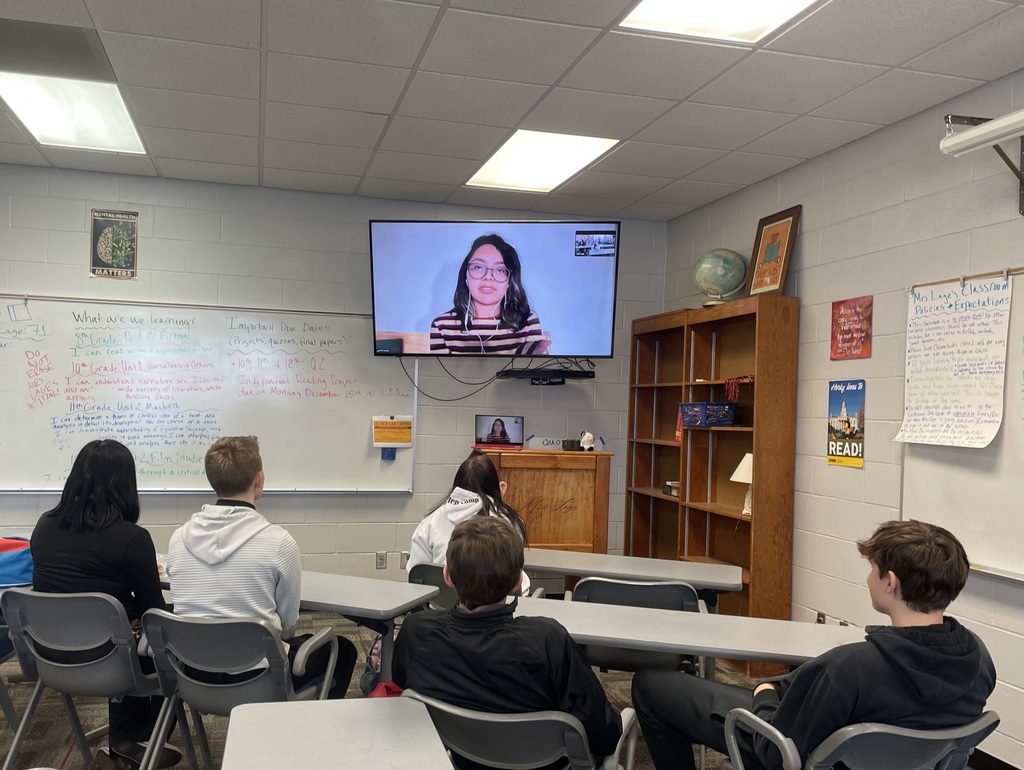 students watching a speaker on a TV screen